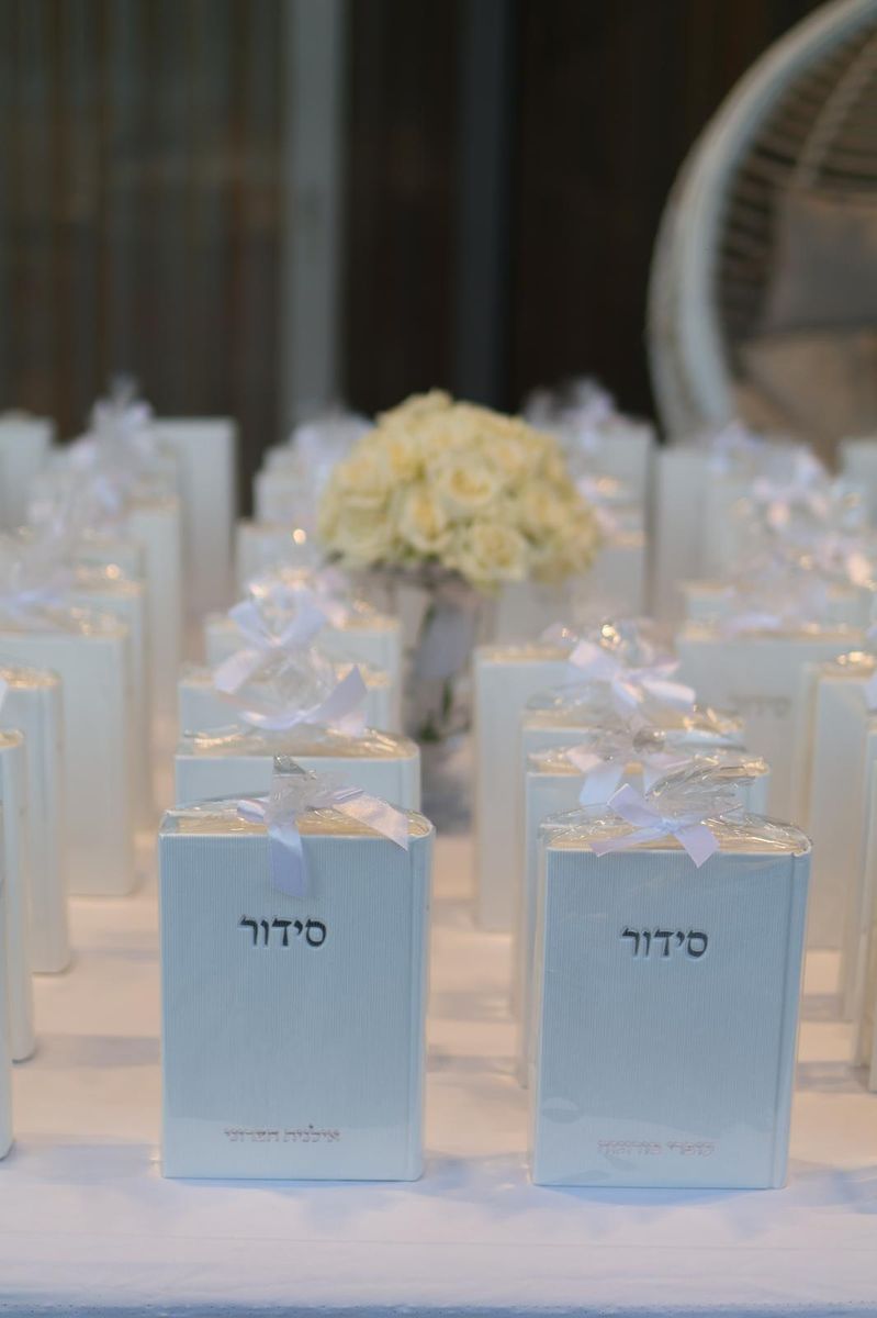 שורות סידורים ומתנות לאורחות עם זר ורדים בהיר